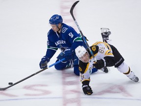 Boston Bruins right wing David Pastrnak (88), of the Czech Republic, falls over Vancouver Canucks defenceman Troy Stecher (51) during the third period of an NHL hockey game in Vancouver, B.C., on Monday March 13, 2017.