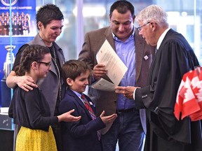 Cal Nichols handing out citizenship certificates to the Bubevski family, Zoran (dad), Renata (mom), Veda, 10 and son Davian, 7, all from Macedonia during a special citizenship ceremony along with eight others, in celebration of our nation’s 150th birthday, at Rogers Place in Edmonton, Saturday, March 18, 2017.  Ed Kaiser/Postmedia