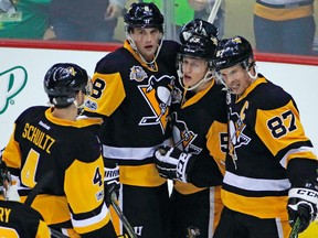 Pittsburgh Penguins' Jake Guentzel (59) celebrates his goal in the first period with Brian Dumoulin (8), Sidney Crosby (87) and Justin Schultz (4) during an NHL hockey game against the New Jersey Devils in Pittsburgh,  March 17, 2017. (GENE J. PUSKAR/AP)