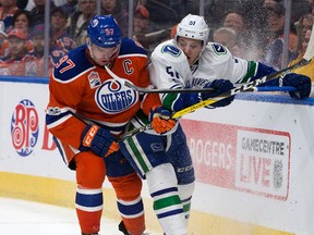 Edmonton Oilers centre Connor McDavid, left, battles with Vancouver Canucks defenceman Troy Stecher at Rogers Place on Saturday, March 18, 2017. The Oilers defeated the Canucks 2-0.