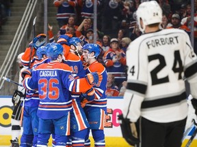 A group of Edmonton Oilers celebrate a goal as Los Angeles Kings' Derek Forbort skates by in Edmonton on Dec. 29, 2016. (The Canadian Press)