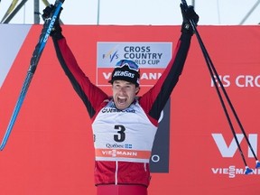 Canada's Alex Harvey leaps on the podium as he celebrates his second place finish in the men's 15 km Pursuit Free on March 19, 2017 at the cross country World Cup in Quebec City. (THE CANADIAN PRESS/Jacques Boissinot)