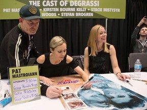 Former cast members of the television show "Degrassi" Stefan Brogan, left to right, Stacie Mistysyn and Kirsten Bourne sign a poster for a fan as they make an appearance at Toronto Comicon, on Sunday, March 19, 2017. THE CANADIAN PRESS/Chris Young