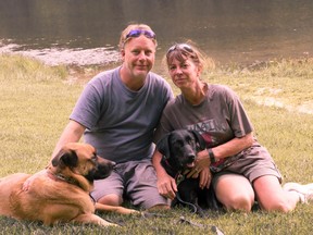 In this Aug. 22, 2015 photo provided by Amy Hunter, John and Amy Hunter are pictured with their dogs, Apollo, left, and Rubi, a black Labrador retriever, in Brown County State Park south of their home in Indianapolis, Ind. The couple is childless by choice and Amy is a stay-at-home pet mom. (Amy Hunter via AP)
