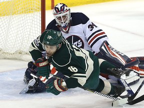 Minnesota Wild forward Jason Zucker trips on the stick of Winnipeg Jets goaltender Michael Hutchinson in Winnipeg on Sun., March 19, 2017. Kevin King/Winnipeg Sun/Postmedia Network