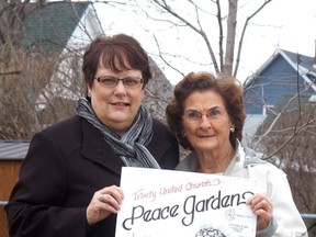 Cheryl Kirk and Jean Bolt show off plans for a new memorial and peace garden that will be constructed outside of Trinity United Church starting this spring.