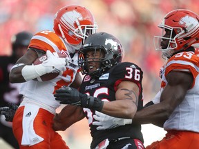 Stampeders' Glenn Love (middle) blocks Lions' Chris Rainey (left) during CFL Western Final action at McMahon Stadium in Calgary on Nov. 20, 2016. (Leah hennel/Postmedia/Files)