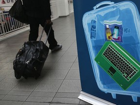 A traveller walks past a TSA pre-check application centre at Terminal C of the LaGuardia Airport on Jan. 27, 2014 in New York City. (Photo by John Moore/Getty Images)