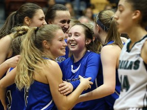 Oak Park Raiders guard Deidre Bartlett (centre) is mobbed by teammates as they celebrate their victory over the Vincent Massey Trojans in the AAAA provincial basketball final on Monday. (Kevin King/Winnipeg Sun)