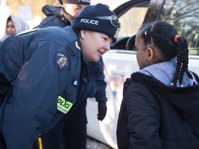 An RCMP officer comforts a young asylum claimant after crossing the border into Canada from the United States Friday, March 17, 2017 near Hemmingford, Que. THE CANADIAN PRESS/Paul Chiasson