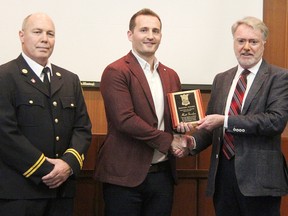 Matt Gordon, middle, receives the inaugural Sarnia Bravery Award from Sarnia Mayor Mike Bradley Monday in council chambers. Standing with them is Sarnia Fire Capt. Tom Ennett. Gordon assisted firefighters rescuing a drowning boater and his dog from stormy waters in Lake Huron last September. Tyler Kula/Sarnia Observer/Postmedia Network