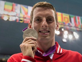 Canadian swimmer Ryan Cochrane shows off his silver medal from the men's 1,500-metre freestyle event at the 2012 Olympic Games in London on Aug. 4, 2012. The two-time Olympic medallist is retiring from swimming. (Frank Gunn/The Canadian Press/Files)