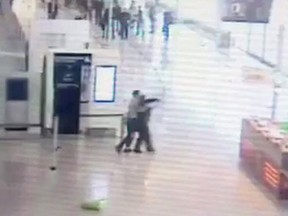 In this image taken from video of CCTV footage provided to AP on the condition that its source not be revealed, suspected Islamic extremist Ziyed Ben Belgacem, center left, holds a soldier after grabbing her from behind at Paris’ Orly airport, Saturday, March 18, 2017. (CCTV via Mobile Phone via AP)