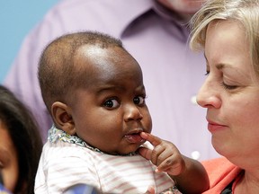 Foster mom Nancy Swabb holds Dominique, a 10-month-old baby born with two spines and an extra set of legs protruding from her neck during a news conference, Tuesday, March 21, 2017, at Advocate Children's Hospital in Park Ridge, Ill. (AP Photo/Teresa Crawford)