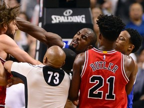 Raptors forward Serge Ibaka (centre) strikes out at Bulls centre Robin Lopez (left) during a scuffle in second half NBA action in Toronto on Tuesday, March 21, 2017. (Frank Gunn/The Canadian Press)