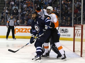 Jets defenceman Dustin Byfuglien (left) and Flyers forward Wayne Simmonds battle in front of Michael Hutchinson last night. (Kevin King/Toronto Sun)