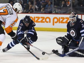 Winnipeg Jets forward Patrik Laine (centre) gets in the way of a shot from Philadelphia Flyers forward Wayne Simmonds in front of goaltender Michael Hutchinson at the MTS Centre last night. (Kevin King/Winnipeg Sun)