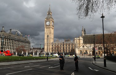 Armed police officers stand guard outside the Houses of Parliament in London, Wednesday, March 23, 2017 after the House of Commons sitting was suspended as witnesses reported sounds like gunfire outside. The leader of Britain's House of Commons says a man has been shot by police at Parliament. David Liddington also said there were "reports of further violent incidents in the vicinity." (AP Photo/Kirsty Wigglesworth) ORG XMIT: TH106