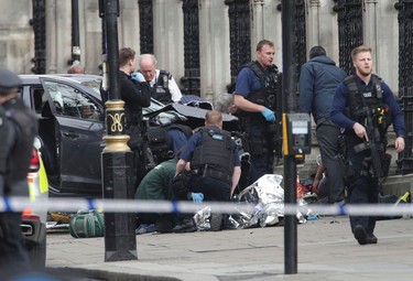 Emergency personnel tend to an injured person close to the Palace of Westminster, London, Wednesday, March 22, 2017.  London police say officers called to a 'firearms incident' on Westminster Bridge, near Parliament. The leader of Britain's House of Commons says a man has been shot by police at Parliament. David Liddington also said there were "reports of further violent incidents in the vicinity."  Britain's MI5 says it is too early to say if the incident is terror-related. (Yui Mok/PA via AP). ORG XMIT: LON838