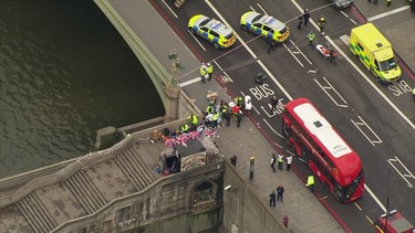 In this image taken from video  emergency personnel gather around a body on the southside of Westminster Bridge that leads to the  Houses of Parliament in London, Wednesday, March 23, 2017 after the House of Commons sitting was suspended as witnesses reported sounds like gunfire outside. The leader of Britain's House of Commons says a man has been shot by police at Parliament. David Liddington also said there were "reports of further violent incidents in the vicinity." (ITN via AP) ORG XMIT: LON834