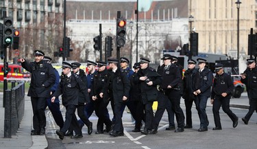 Police officers walk through Parliament in London, Wednesday, March 23, 2017 after the House of Commons sitting was suspended as witnesses reported sounds like gunfire outside. The leader of Britain's House of Commons says a man has been shot by police at Parliament. David Liddington also said there were "reports of further violent incidents in the vicinity."(AP Photo/Kirsty Wigglesworth) ORG XMIT: TH111