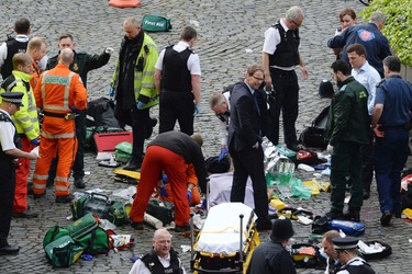 Conservative MP Tobias Ellwood, centre, stands amongst the emergency services at the scene outside the Palace of Westminster, London, Wednesday, March 22, 2017.  London police say they are treating a gun and knife incident at Britain's Parliament "as a terrorist incident until we know otherwise." The Metropolitan Police says in a statement that the incident is ongoing. It is urging people to stay away from the area. Officials say a man with a knife attacked a police officer at Parliament and was shot by officers. Nearby, witnesses say a vehicle struck several people on the Westminster Bridge.  (Stefan Rousseau/PA via AP). ORG XMIT: LON844