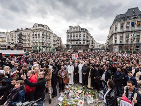 People stand for a moment of silence at the Bourse during the one-year anniversary for Brussels attacks victims in Brussels on Wednesday, March 22, 2017. Belgian leaders, victims and families of those who died in the suicide bomb attacks on the Brussels airport and subway are marking the first anniversary of the attacks, which killed 32 people and wounded more than 300 others. (AP Photo/Geert Vanden Wijngaert)