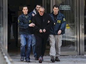 FBI agents flank Vincent Asaro as they escort the reputed mobster from FBI offices in lower Manhattan, Thursday, Jan. 23, 2014, in New York. (AP Photo/Newsday, Charles Eckert)