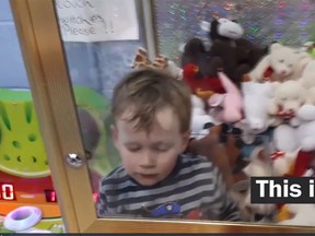 Jamie, 3, climbed inside a big claw machine filled with cuddly stuffed teddy bears, doggies, giraffes and dragons. (Screengrab)