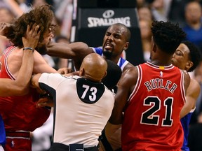 Raptors forward Serge Ibaka (centre) lands a strike on Bulls centre Robin Lopez (left) during a scuffle in second half NBA action in Toronto on Tuesday, March 21, 2017. (Frank Gunn/The Canadian Press)