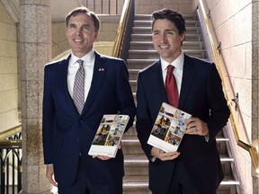 Finance Minister Bill Morneau and Prime Minister Justin Trudeau hold copies of the federal budget in the House of Commons in Ottawa, Wednesday. ADRIAN WYLD / THE CANADIAN PRESS