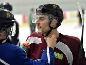 London Knights forward Janne Kuokkanen checks out the cut on Sam Miletic?s chin during practice at the Western Fair on Wednesday. (MORRIS LAMONT, The London Free Press)