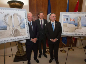 From left, Gov. Gen. David Johnston, Bruce Burrows, chair of the 2017 Vimy Reception Committee, and French Ambassador to Canada Nicolas Chapuis assist La Poste of France unveil two commemorative stamps designed in honour of the 100th anniversary of the Battle of Vimy Ridge. WAYNE CUDDINGTON / POSTMEDIA