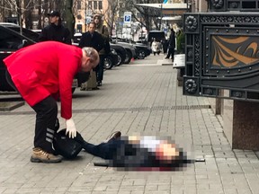A hotel employee tries to help Denis Voronenkov minutes after he was shot in Kiev, Ukraine, Thursday, March 23, 2017. Ukrainian police said Voronenkov was shot dead Thursday by an unidentified gunman at the entrance of an upscale hotel in the Ukrainian capital. Voronenkov, 45, a former member of the communist faction in the lower house of Russian parliament, had moved to Ukraine last fall and had been granted Ukrainian citizenship. (AP Photo/Alisa Berezutsskaya)