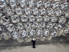 In this March 21, 2017 photo engineer Volkmar Dohmen stands in front of xenon short-arc lamps in the DLR German national aeronautics and space research center in Juelich, western Germany. The lights are part of an artificial sun that will be used for research purposes. (Caroline Seidel/dpa via AP)