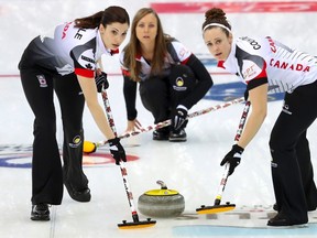 Canada's Lisa Weagle, left, and Joanne Courtney, right, sweep a path for the stone as Rachel Homan, centre, watches during their match against Italy in the CPT World Women's Curling Championship 2017 in Beijing, Thursday, March 23, 2017. (AP Photo/Mark Schiefelbein)