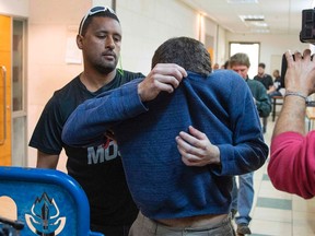 American-Israeli Jewish teenager (C), accused of making dozens of anti-Semitic bomb threats in the United States and elsewhere, is escorted by guards as he leaves the Israeli Justice court in Rishon Lezion on March 23, 2017. The arrest comes after a wave of bomb threats to American Jewish institutions since the start of the year spread concern and political backlash in the United States. (AFP PHOTO / JACK GUEZJACK GUEZ/AFP/Getty Images)