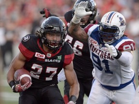 Ottawa Redblacks' Kienan Lafrance (27) makes his way past Montreal Alouettes' Alan-Michael Cash (91) during first half CFL action on Friday, Aug. 19, 2016 in Ottawa. The Toronto Argonauts have signed international defensive tackle Cash. (THE CANADIAN PRESS)