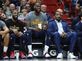 Cavaliers' Kyrie Irving (left) LeBron James (center) and J.R. Smith (right) watch from the bench during first half NBA action against the Heat in Miami on March 4, 2017. (Lynne Sladky/AP Photo)