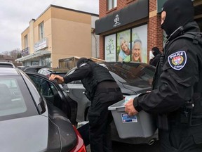 Police carry out cannabis products from Magna Terra. JACQUIE MILLER / POSTMEDIA