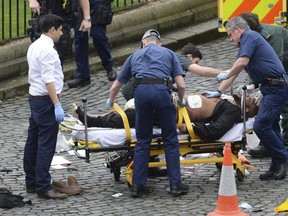 Attacker Khalid Masood is treated by emergency services outside the Houses of Parliament London.(Stefan Rousseau/PA via AP.