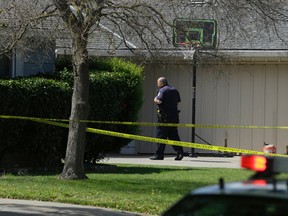A Sacramento City Police officer walks to the home where four people were found dead, Thursday, March 23, 2017, in Sacramento, Calif. A suspect is being held in San Francisco. Police are not saying how the four were killed and are not identifying the victims, including their genders and ages. (AP Photo/Rich Pedroncelli)