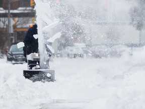 A man clears snow along Waverley Street in Ottawa following a late winter storm. March 15,2017.