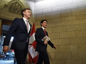 Finance Minister Bill Morneau and Prime Minister Justin Trudeau leave the Prime Minister's office holding copies of the federal budget in Ottawa, Wednesday, March 22, 2017. THE CANADIAN PRESS/Sean Kilpatrick