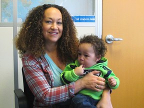 In this March 20, 2017 photo, Rachel Dolezal poses for a photo with her son, Langston in the bureau of the Associated Press in Spokane, Wash. Dolezal, who has legally changed her name to Nkechi Amare Diallo, rose to prominence as a black civil rights leader, but then lost her job when her parents exposed her as being white and is now struggling to make a living. (AP Photo/Nicholas K. Geranios)