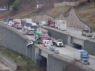 Emergency crews and tow truck workers tend to a truck hanging over an embankment on Highway 17 in Surrey. (Postmedia Network)