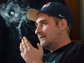 Medicinal marijuana user Justin Polci fires up a joint at his south London home on Tuesday March 21, 2017. (MORRIS LAMONT, The London Free Press)