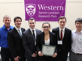 More than 70 Western University students competed in the 12th annual Capstone Engineering Design and Competition held at the Western Sarnia-Lambton Research Park Friday. Students presented projects in the categories of petrochemicals, green and biochemical processes and specialty chemicals to industry judges. Pictured here are Tim Korstanje, of Suncor, far left, and Marcus Pang, of Shell, far right, with students Matthew Tucci, Tyler Deighton, Ariel Porat and Austin Cameron. These students picked up first place in the petrochemicals category. (Barbara Simpson/Sarnia Observer)