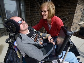 Tanya Dallaire tends to her brother Shawn Eyre, 50, during a press conference at Participation House in London to draw attention to the need for more assisted living facilities on Friday March 24, 2017. (MORRIS LAMONT, The London Free Press)