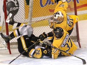 Kingston Frontenacs' Stephen Desrochers takes Hamilton Bulldogs' Matt Luff into Jeremy Helvig's net during Game 1 of Ontario Hockey League Eastern Conference quarter-final action at the Rogers K-Rock Centre on Friday. Ian MacAlpine /The Whig-Standard/Postmedia Network
